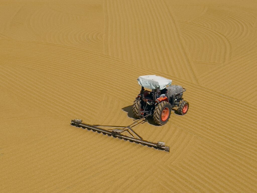 Illustration of a farmer operating a plow in a field, preparing the soil for planting crops.